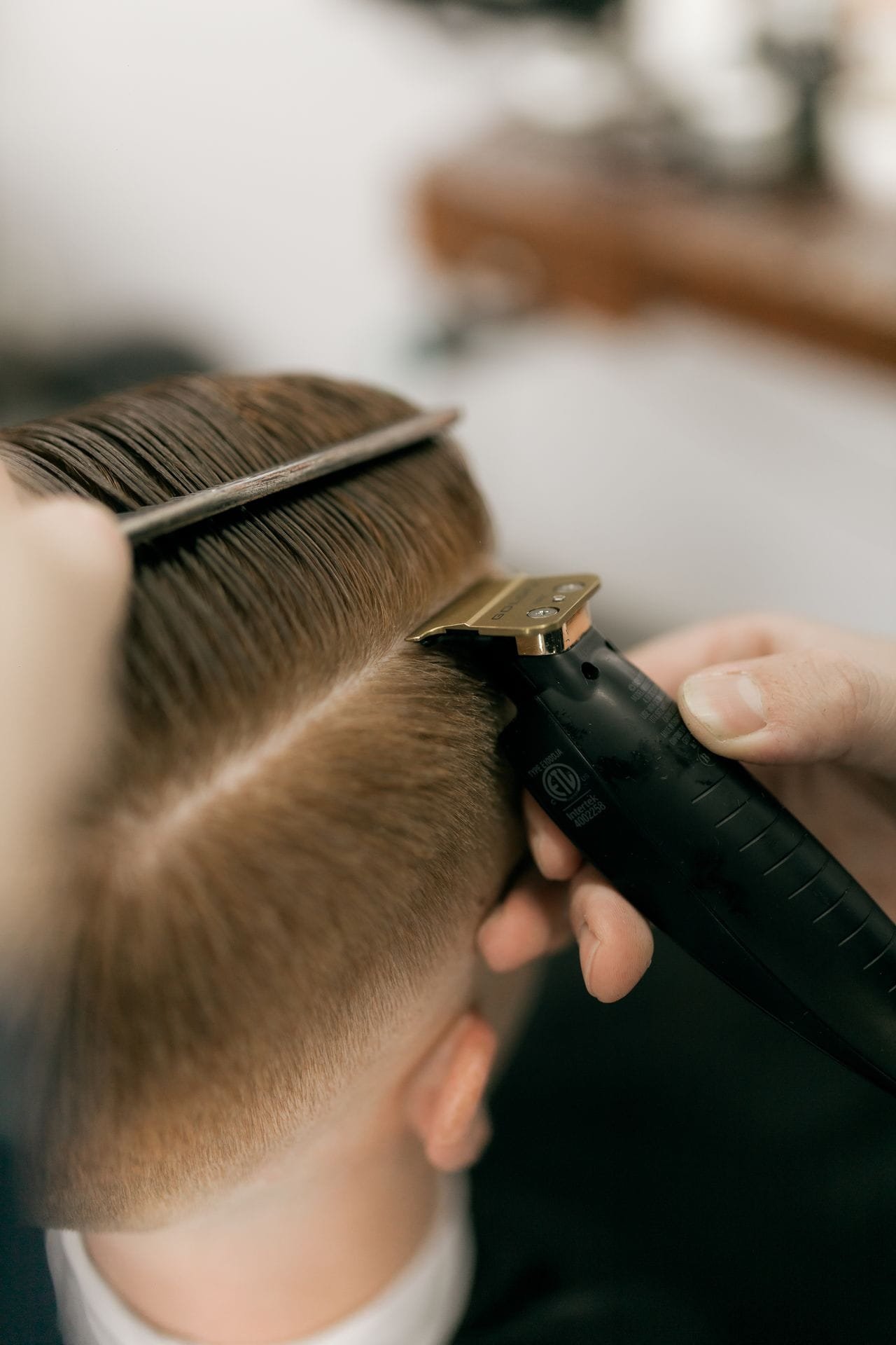 Kapper knipt haar met een tondeuse en een kam